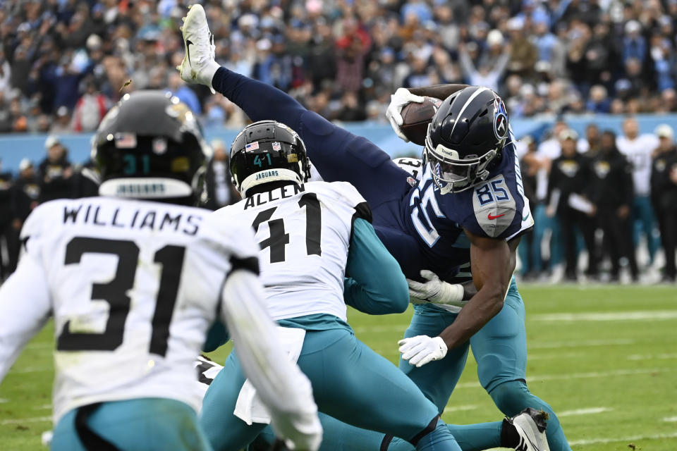 Tennessee Titans tight end Chigoziem Okonkwo (85) dives into the end zone for a touchdown as Jacksonville Jaguars cornerback Darious Williams (31) and linebacker Josh Allen (41) defend during the first half of an NFL football game Sunday, Dec. 11, 2022, in Nashville, Tenn. (AP Photo/Mark Zaleski)