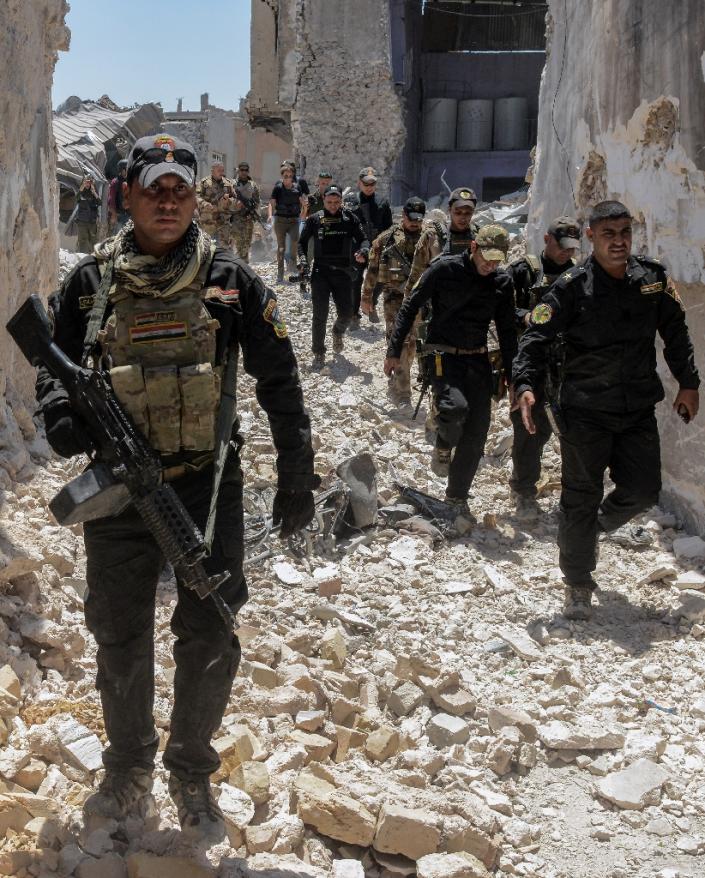 Iraqi forces trudge through the rubble of a building as they advance through the Old City of Mosul on June 25, 2017 (AFP Photo/MOHAMED EL-SHAHED)