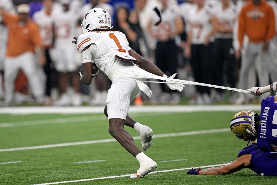 Jan 1, 2024; New Orleans, LA, USA; Texas Longhorns wide receiver Xavier Worthy (1) has his jersey torn while running the ball during the second quarter against the Washington Huskies in the 2024 Sugar Bowl college football playoff semifinal game at Caesars Superdome. Mandatory Credit: Matthew Hinton-USA TODAY Sports