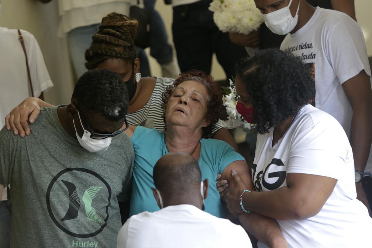 Supported by relatives, Angela Romeu, center, the grandmother of Kathlen Romeu, a young pregnant woman killed by a stray bullet, attends her granddaughter's funeral in Rio de Janeiro, Brazil, Wednesday, June 9, 2021. Romeu was a Black woman living in a working-class neighborhood, or favela, and her death was viewed by many as the all-too-familiar outcome of confrontations between police and traffickers. Rio’s police have said the 20-something interior designer was hit by a single shot in her torso during a shootout with criminals. Officers brought her to a nearby hospital, but neither she nor her baby survived. (AP Photo/Bruna Prado)