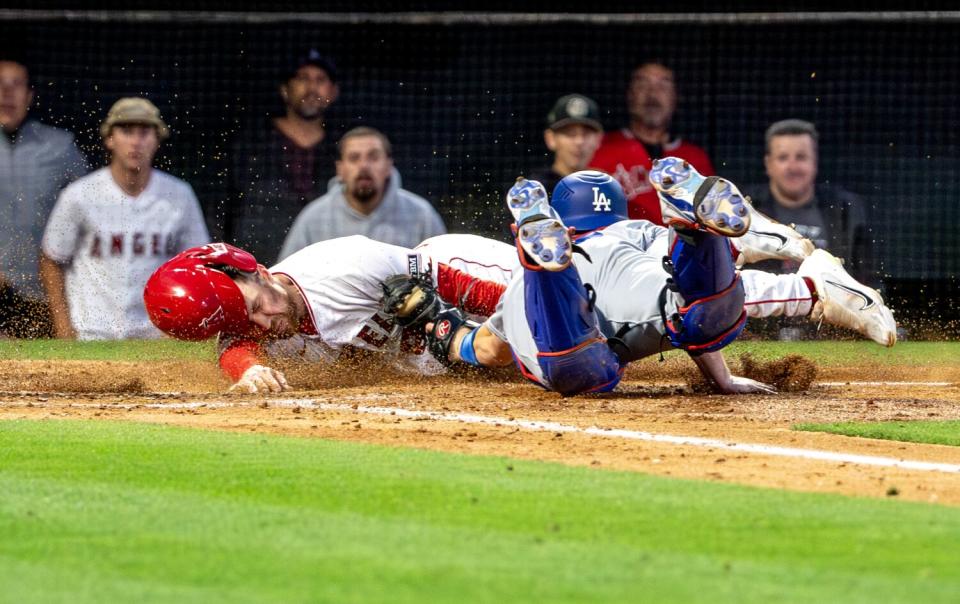 The Angels' Brandon Drury is tagged at home by Dodgers wide receiver Will Smith.