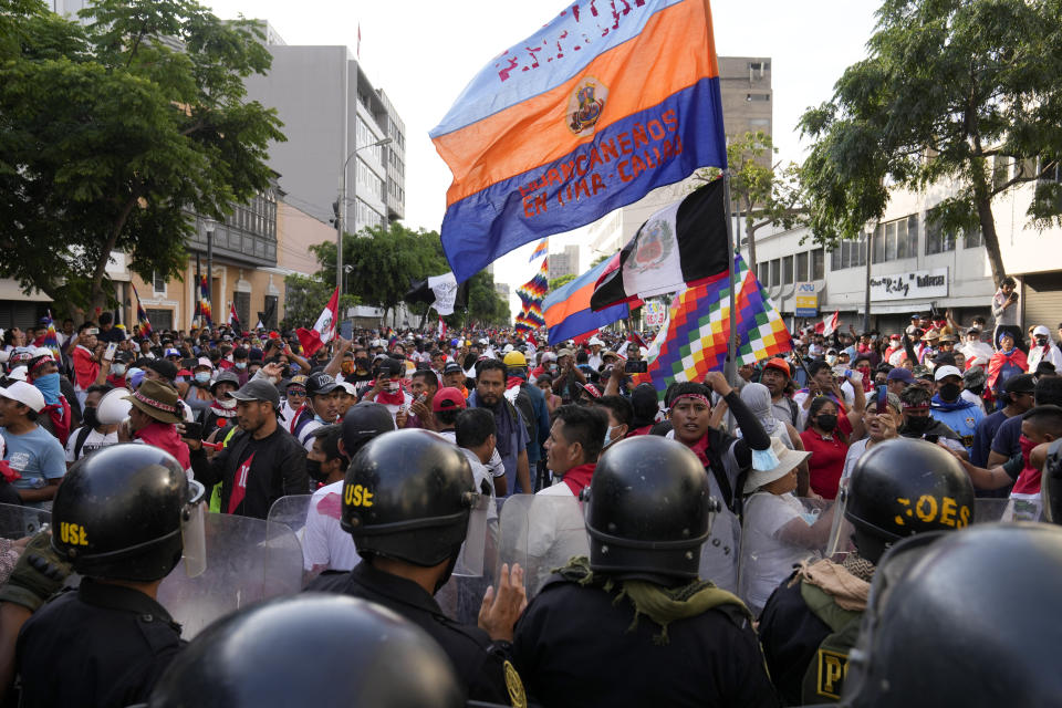 Police block demonstrators who are marching against President Dina Boluarte in downtown Lima, Peru, Thursday, Jan. 19, 2023. Protesters are seeking immediate elections, the resignation of Boluarte, the release from prison of ousted President Pedro Castillo and justice for protesters killed in clashes with police. (AP Photo/Martin Mejia)