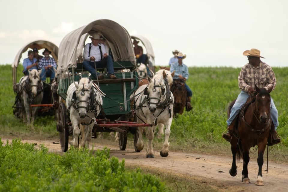Covered wagons from Dodge City, Lyndon, Yoder, Rossville and Tecumseh are driven around Wade Pasture in Wabaunsee County on Saturday as part of Symphony in the Flint Hills.