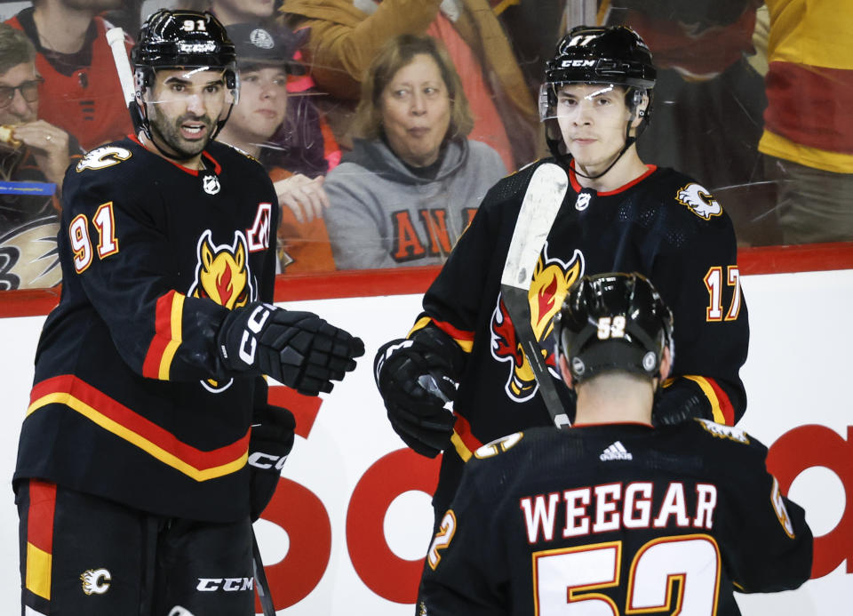 Calgary Flames forward Yegor Sharangovich (17) celebrates his goal against the Anaheim Ducks with forward Nazem Kadri (91) and defenseman MacKenzie Weegar (52) during the second period of an NHL hockey game Tuesday, April 2, 2024, in Calgary, Alberta. (Jeff McIntosh/The Canadian Press via AP)