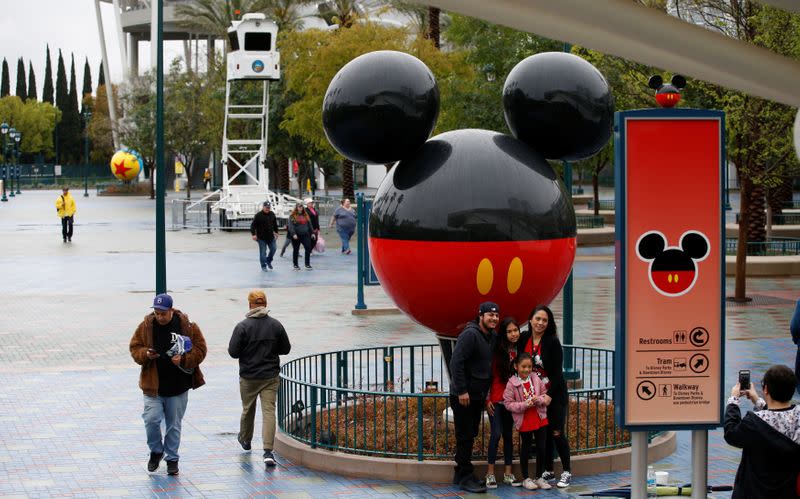 A family poses for a photo at Disneyland theme park in Anaheim