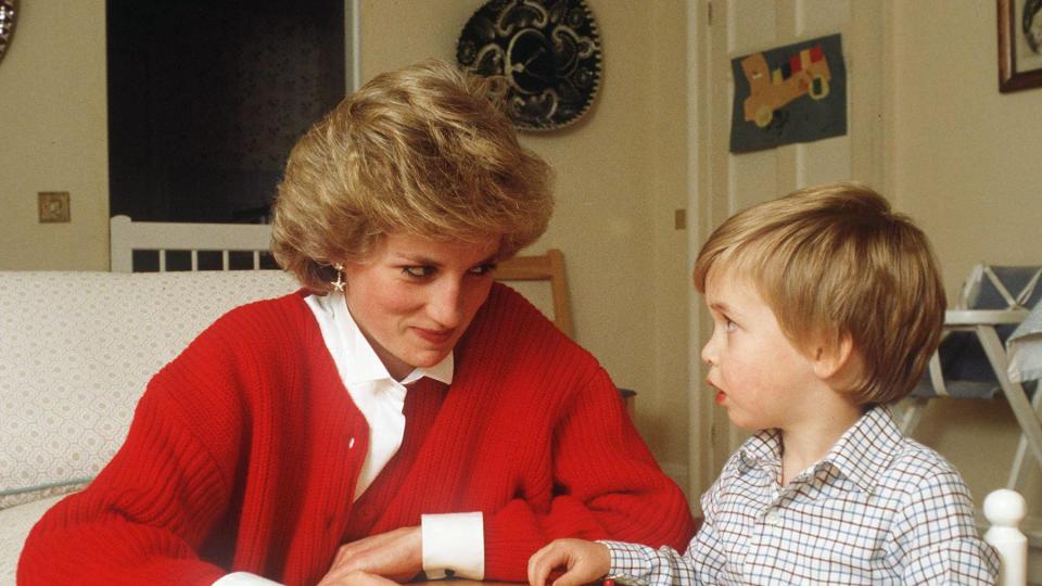 <p>Sweaters were a key piece of Diana's mom wardrobe, like this red cardigan she wore while doing a puzzle at home with William.</p>