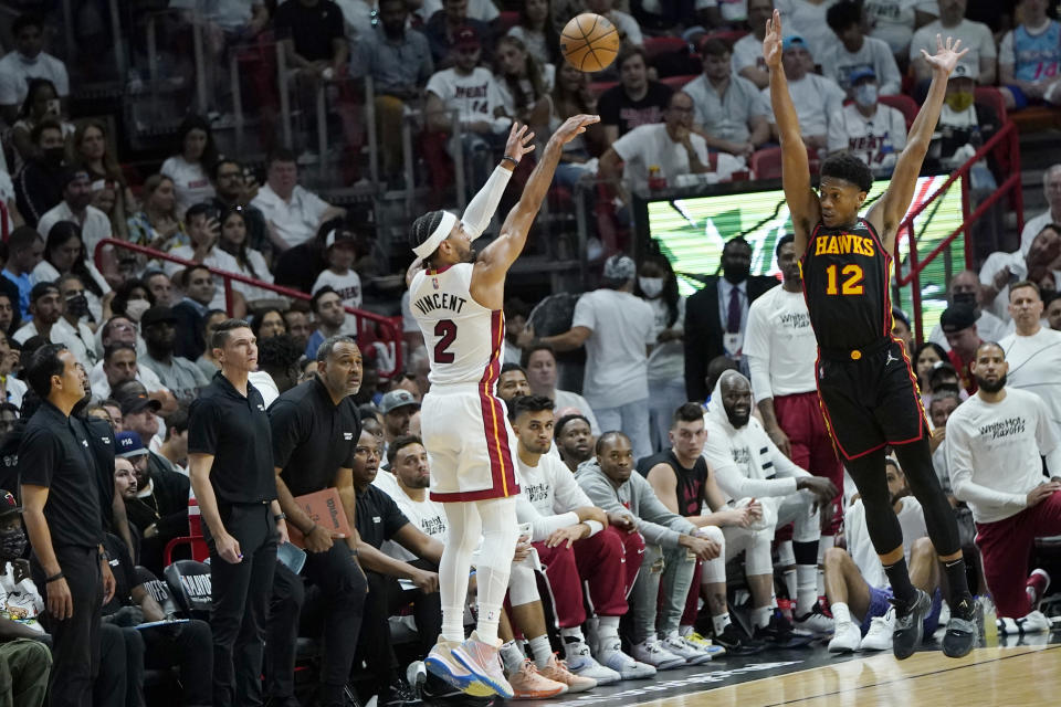 Miami Heat guard Gabe Vincent (2) attempts a three point basket as Atlanta Hawks forward De'Andre Hunter (12) defends during the first half of Game 1 of an NBA basketball first-round playoff series, Sunday, April 17, 2022, in Miami. (AP Photo/Lynne Sladky)