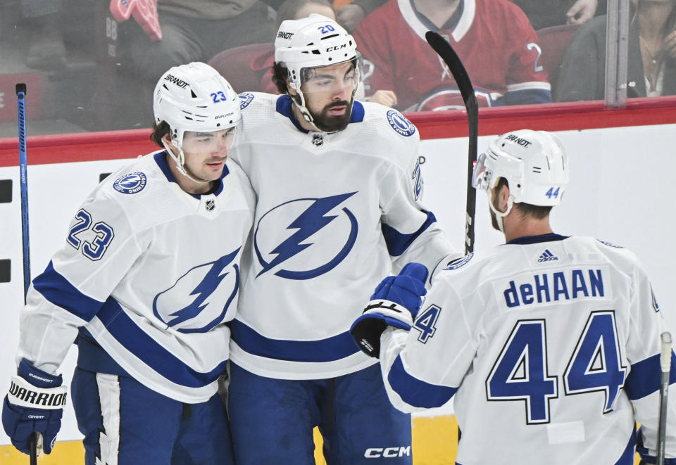 Tampa Bay Lightning's Michael Eyssimont (23) is congratulated by teammates Nicholas Paul (20) and Calvin de Haan (44) after scoring against the Montreal Canadiens during first-period NHL hockey game action in Montreal, Thursday, April 4, 2024. (Graham Hughes/The Canadian Press via AP)