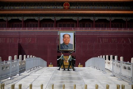 FILE PHOTO: Paramilitary officers change guard in front of the portrait of the late Chinese chairman Mao Zedong in Tiananmen Square in Beijing
