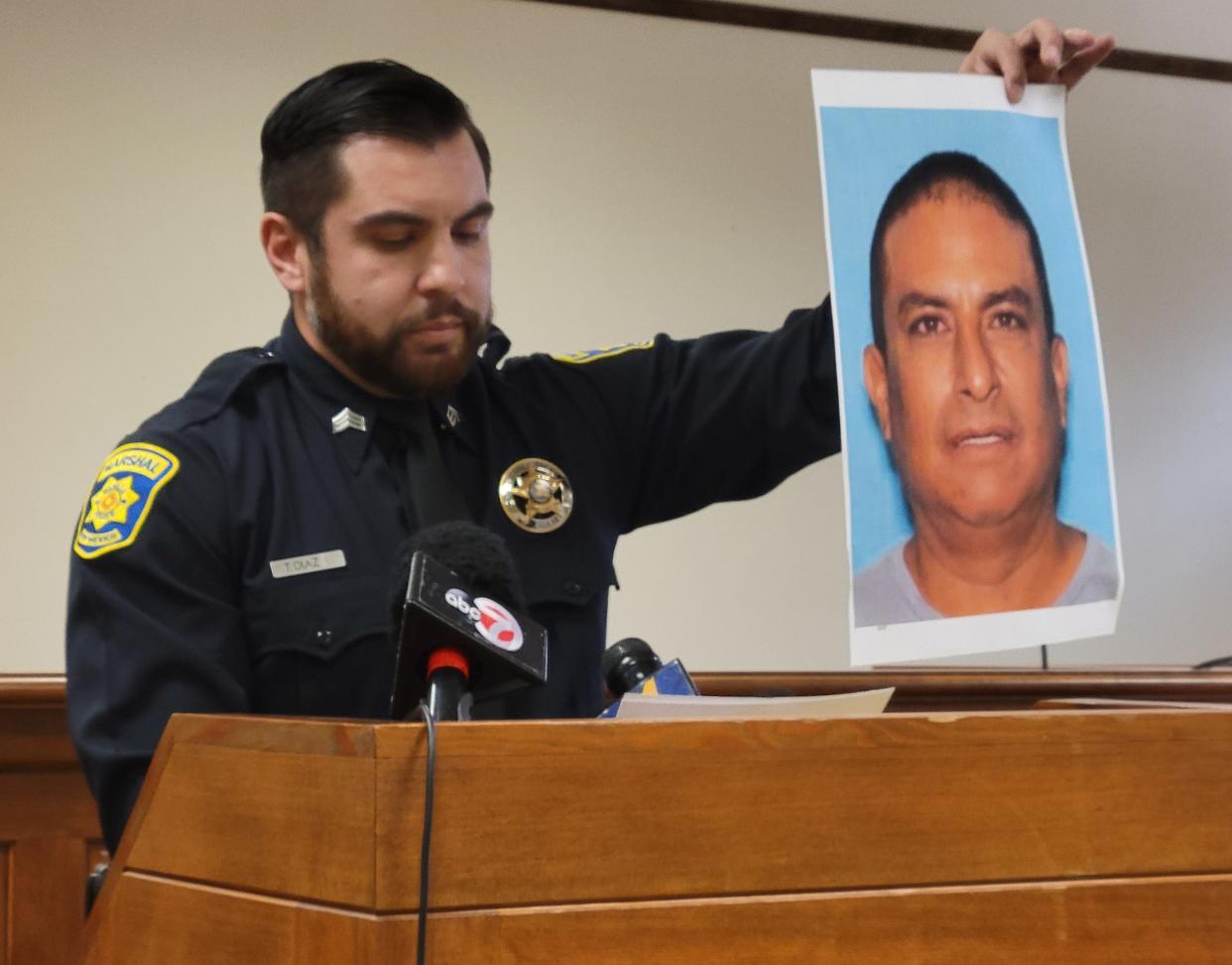 Mesilla Marshals Office Sgt. Tress Diaz holds a photo of Oscar Renee Sandoval, a person of interest in a deadly shooting in Mesilla on Monday.