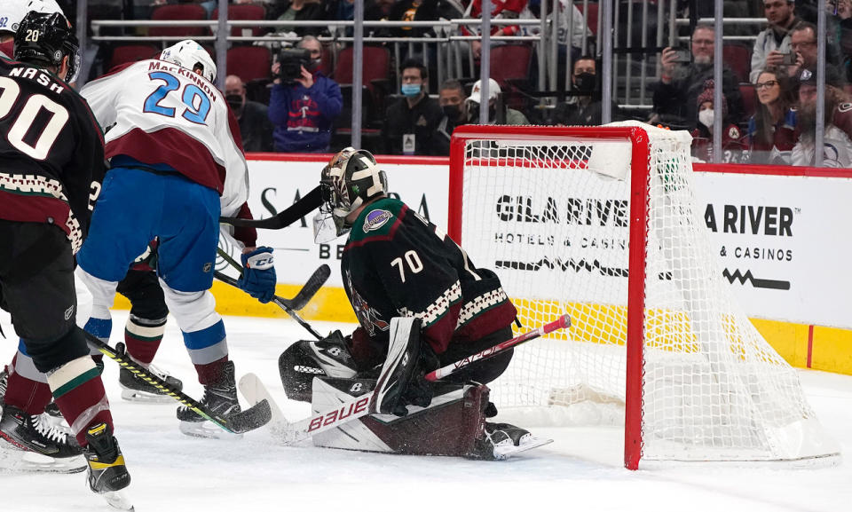 Colorado Avalanche's Nathan MacKinnon (29) scores against the Arizona Coyotes' goalkeeper Karel Vehmelka (70) during the first period of an NHL hockey game Saturday, Jan. 15, 2022, in Glendale, Ariz. (AP Photo/Darryl Webb)