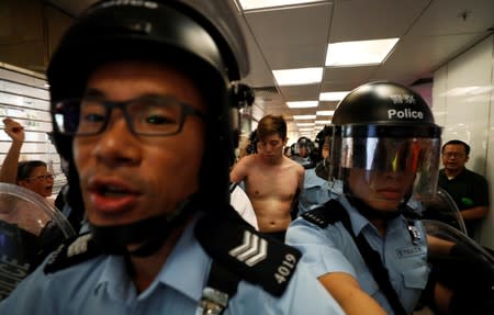 A protester is detained by the police officers at Amoy Plaza shopping mall in Kowloon Bay, Hong Kong