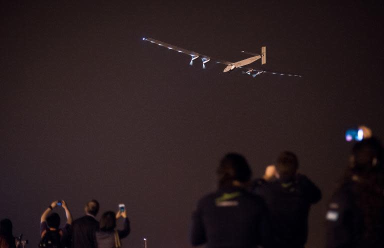 People take pictures as the Swiss-made solar-powered plane Solar Impluse 2 takes off from Nanjing's Lukou International Airport in Nanjing, in China's eastern Jiangsu province, early on May 31, 2015