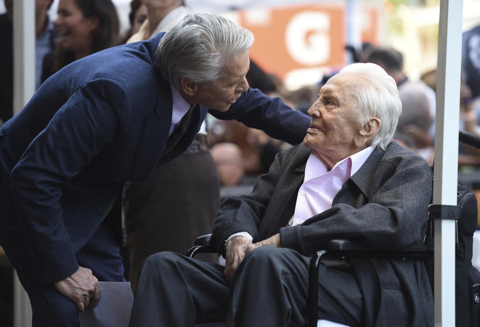 Michael Douglas, left, speaks with his father Kirk Douglas before a Hollywood Walk of Fame star ceremony (Photo by Chris Pizzello/Invision/AP)