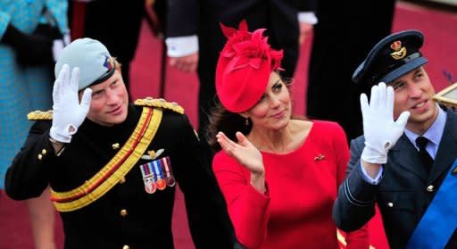 Britain's Catherine, Duchess of Cambridge, (centre) Prince William (right) and Prince Harry (left) wave as they pass the Houses of Parliament aboard the Royal barge, "Spirit of Chartwell"during the diamond jubilee river pageant celebrating Queen Elizabeth II's 60 years on the throne in London on June 3