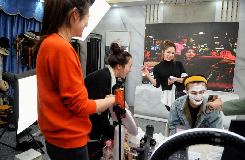 Live-streaming anchor and her assistant promote a facial mask through a live streaming session before the 11.11 Singles' Day shopping festival, at her studio in Hangzhou