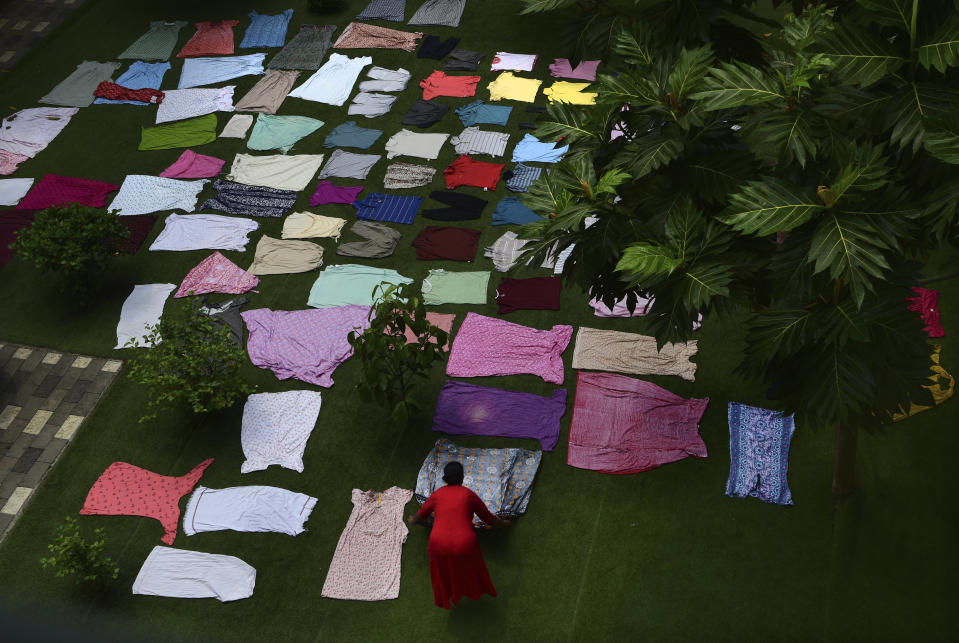 A staffer sun dries the clothes of residents at the Signature senior living facility in Kochi, Kerala state, India, March 6, 2023. “Getting qualified employees is a big challenge today and bringing people from other states doesn’t always work because of language barriers,” said Alex Joseph, the managing trustee of the facility. Joseph added that getting staff from within Kerala is also difficult since most of them aspire to migrate abroad for work. (AP Photo/ R S Iyer)