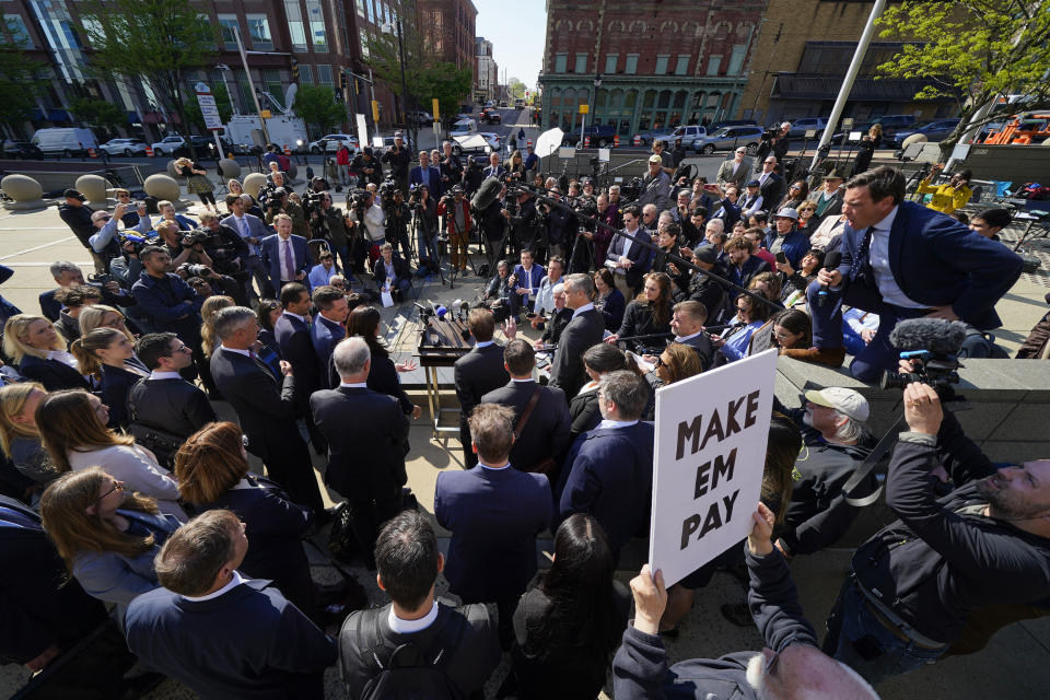 Reporters surround attorneys for Dominion Voting Systems during a news conference outside the New Castle County Courthouse in Wilmington, Del., after the defamation lawsuit by Dominion Voting Systems against Fox News was settled just as the jury trial was set to begin, Tuesday, April 18, 2023. (AP Photo/Julio Cortez)