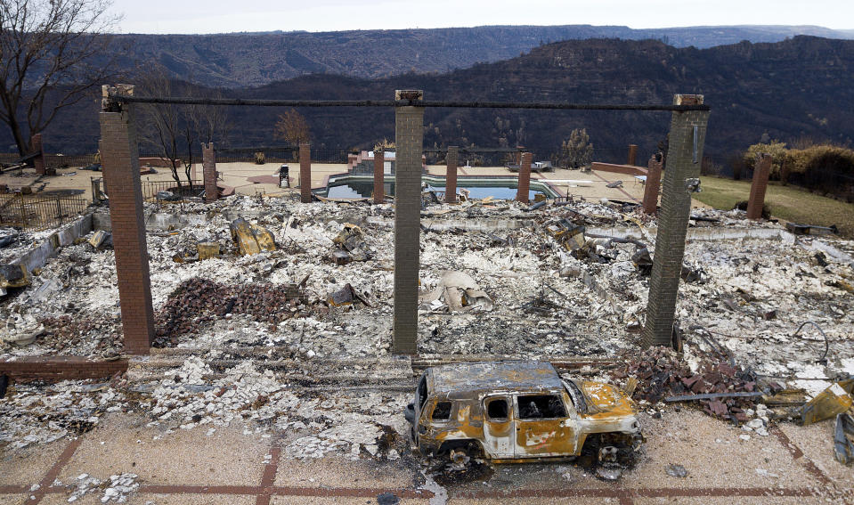 FILE - A vehicle sits in front of a home leveled by the Camp Fire in Paradise, Calif., Dec. 3, 2018. The Camp Fire bears many similarities to the deadly wildfire in Hawaii. Both fires moved so quickly residents had little time to escape. (AP Photo/Noah Berger, File)
