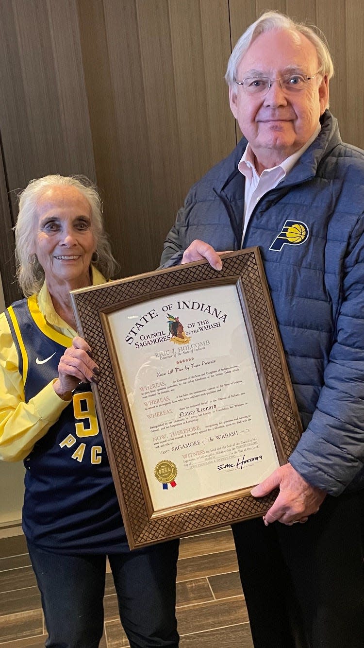 Nancy Leonard is presented the Sagamore of the Wabash by Earl Goode, the chief of staff for Gov. Eric Holcomb during halftime of Monday night's Pacers game.
