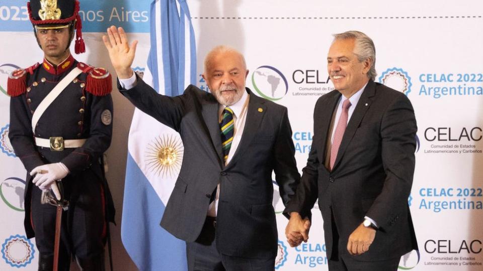 Lula da Silva y Alberto Fernández cogidos de la mano con un guardia al lado