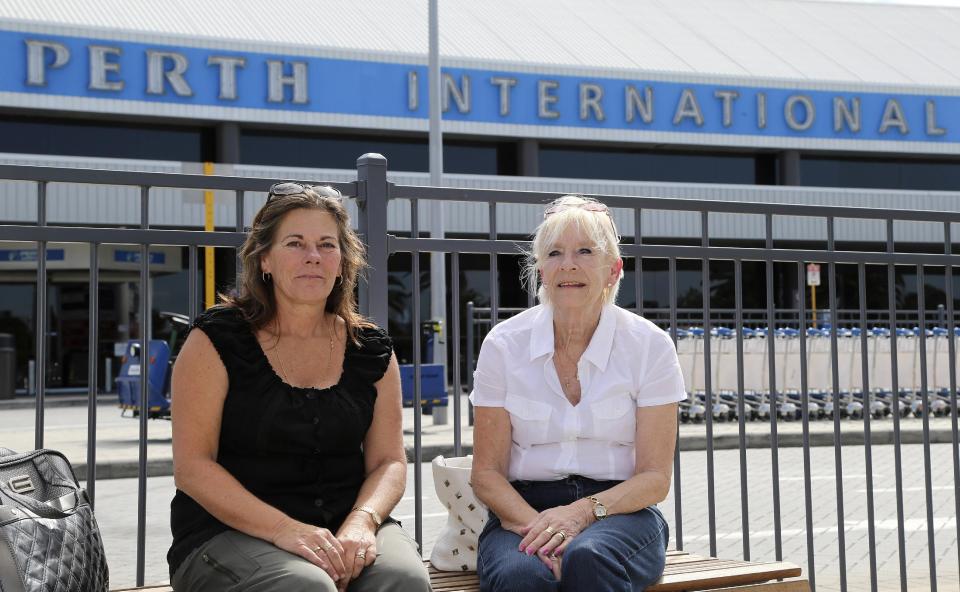 In this April 10, 2014 photo, Joyce Cole, right, and her daughter Jane Barnes pose for a photo at Perth International Airport before departing on a flight to Bali for holiday, in Perth, Australia. At airports across Asia and around the world, Flight 370 and its 239 passengers and crew, now lost for more than a month, are topics of avid speculation and sometimes anxiety. Passengers typically remain confident about the safety of air travel, but some are distressed by the disappearance, which - given the number of people involved - is unprecedented in aviation industry. (AP Photo/Rob Griffith)