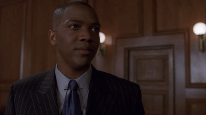 Charles Gunn stands in a courtroom wearing a slick suit in the Angel episode "Conviction"