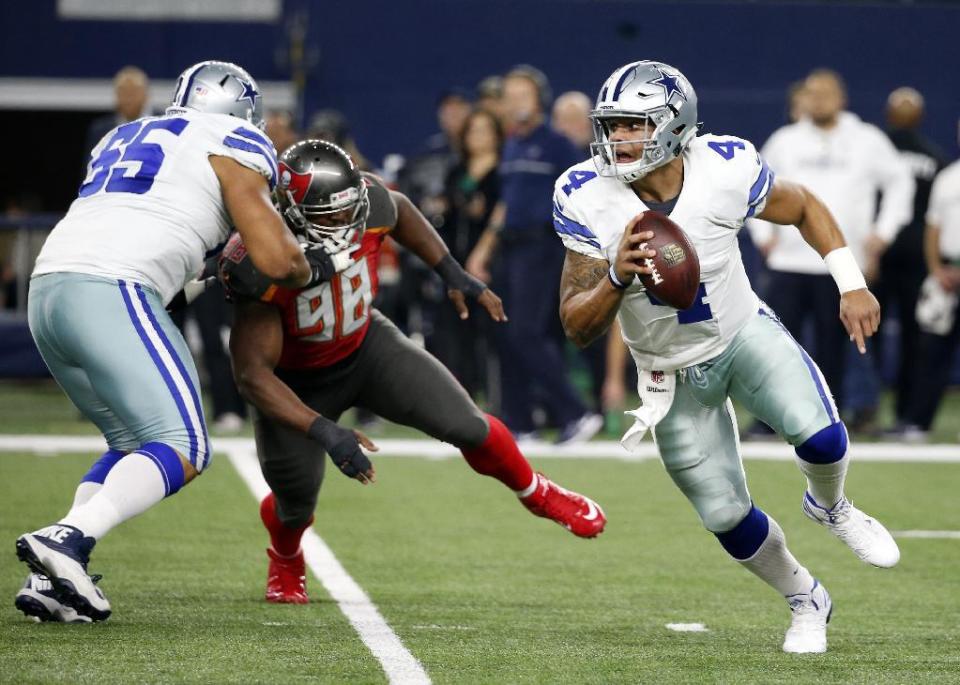 Dallas Cowboys' Ronald Leary (65) provides protection against Tampa Bay Buccaneers' Clinton McDonald (98) as Dak Prescott (4) scrambles out of the pocket in the first half of an NFL football game, Sunday, Dec. 18, 2016, in Arlington, Texas. (AP Photo/Michael Ainsworth)