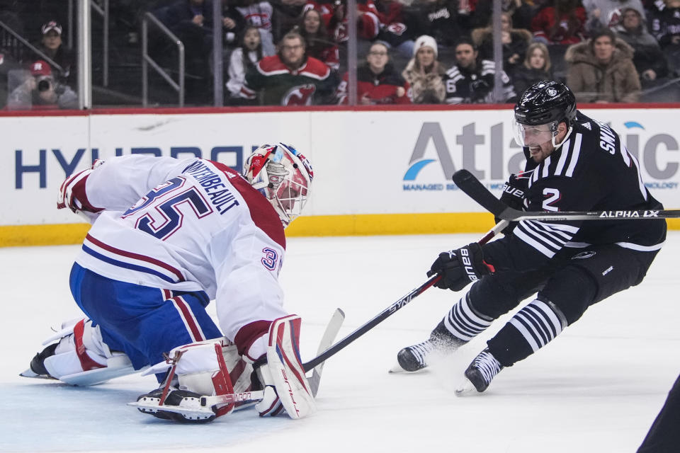 Montreal Canadiens goaltender Sam Montembeault (35) stops a shot on goal by New Jersey Devils' Brendan Smith (2) during the second period of an NHL hockey game Tuesday, Feb. 21, 2023, in Newark, N.J. (AP Photo/Frank Franklin II)