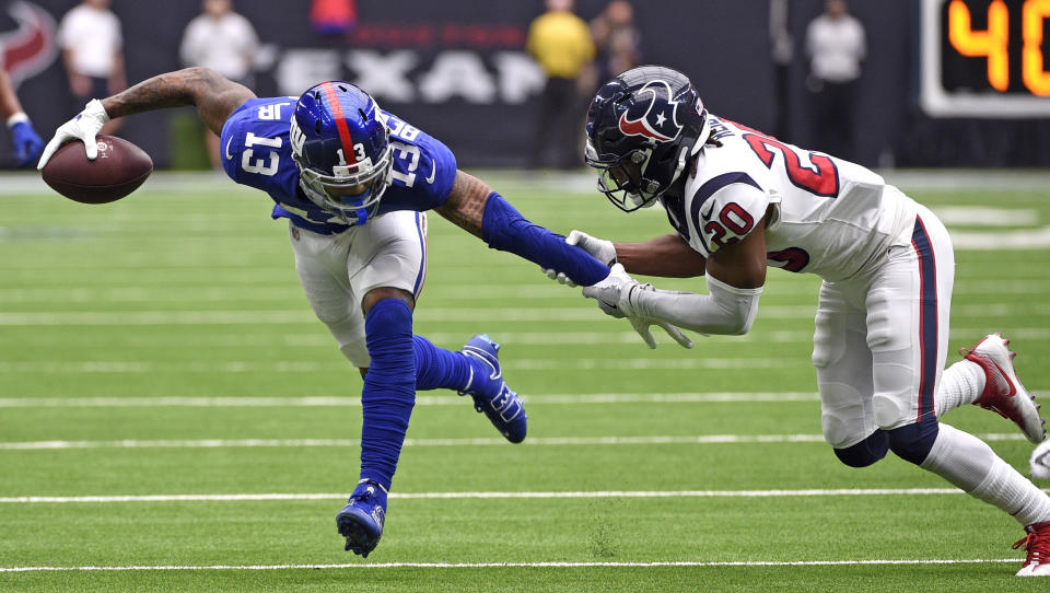 Houston Texans defensive back Justin Reid (20) grabs the arm of New York Giants wide receiver Odell Beckham Jr. (13) during the first half of an NFL football game Sunday, Sept. 23, 2018, in Houston. (AP Photo/Eric Christian Smith)