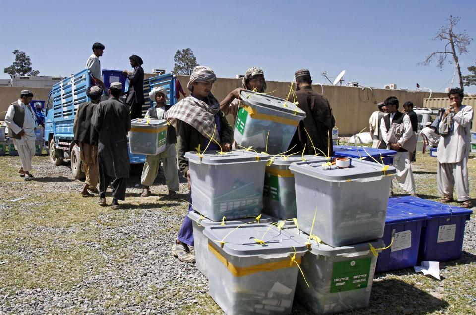 Afghan election workers carry out of a ballot box from a truck at the warehouse of the Independent Elections Commission in Kandahar, Afghanistan, Monday, April 7, 2014. (AP Photo/Allauddin Khan)