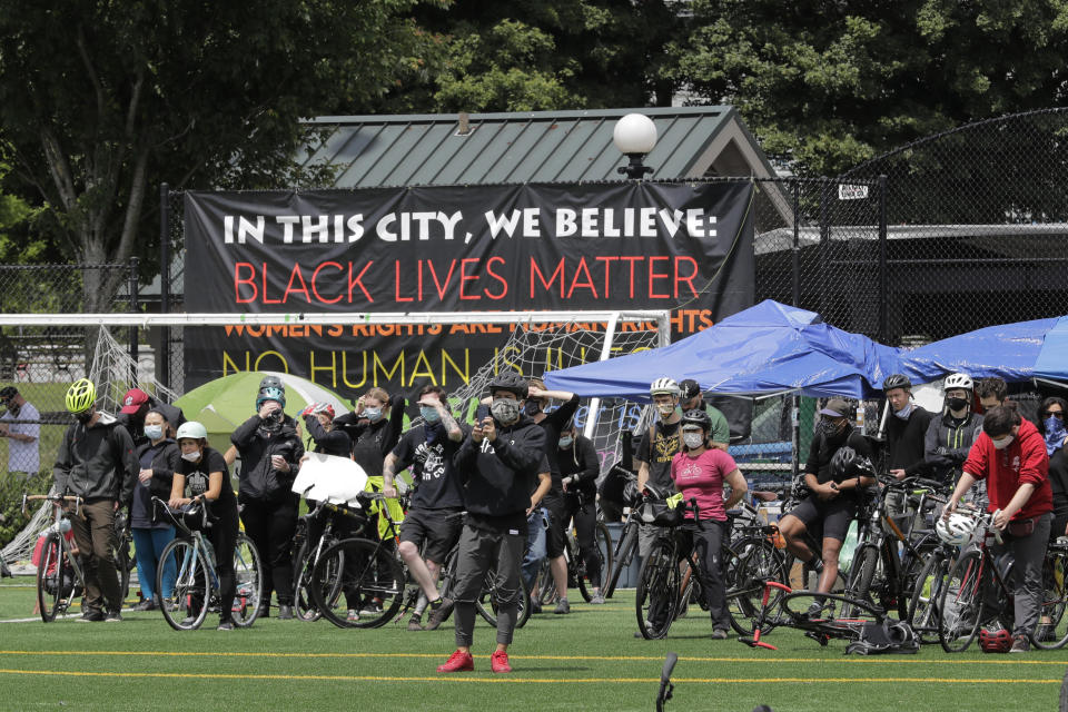 Cyclists gather at Cal Anderson Park after taking part in the "Ride for Justice," Thursday, June 11, 2020, Seattle. People rode to the park and then took part in a rally to protest against police brutality and racial inequality. (AP Photo/Ted S. Warren)