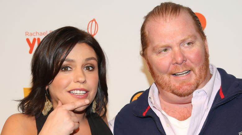 Rachael Ray standing next to and pointing at Mario Batali
