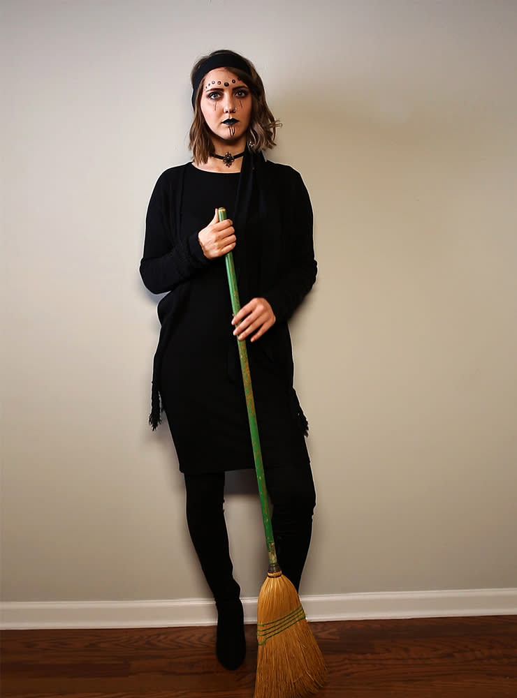 A woman is dressed in a DIY witch costume.