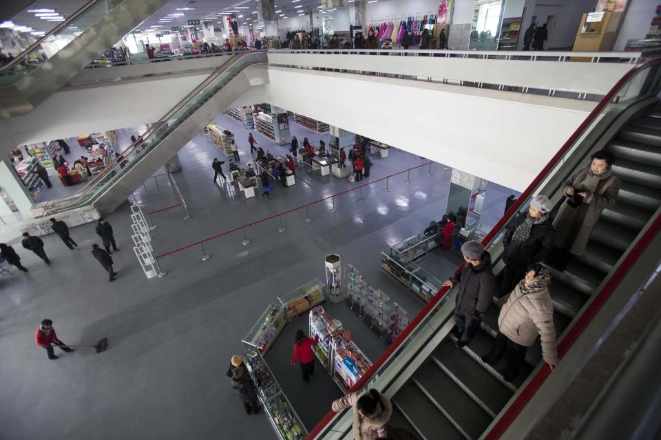 In this Thursday, Jan. 19, 2012 photo, people make their way around the Kwangbok Area shopping center to buy groceries, clothing, and household goods in Pyongyang, North Korea. A new culture of commerce is springing up, with China as its inspiration and source. The new consumerism is part of a campaign launched three years ago to build up the economy, and so the image of new leader Kim Jong Un. (AP Photo/David Guttenfelder)