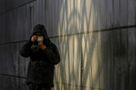 A resident adjusts her face mask as she walks by a tunnel in Beijing, Monday, Dec. 5, 2022. China is easing some of the world's most stringent anti-virus controls and authorities say new variants are weaker. But they have yet to say when they might end a "zero-COVID" strategy that confines millions of people to their homes and set off protests and demands for President Xi Jinping to resign. (AP Photo/Andy Wong)