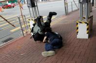 A riot police officer detains an anti-government protester in Tsuen Wan, near the site where police shot a protester with live ammunition on China's National Day in Hong Kong