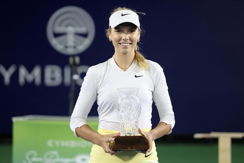 Katie Boulter smiles as she holds the trophy.