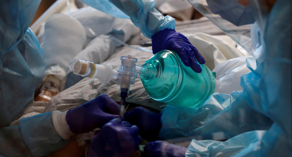Care workers insert an endotracheal tube into a COVID-19 positive patient in the intensive care unit (ICU) at Sarasota Memorial Hospital in Florida. REUTERS/Shannon Stapleton
