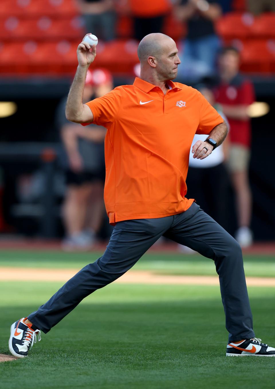 Oklahoma State men's basketball coach Steve Lutz throws the first pitch before the college Bedlam baseball game between Oklahoma State University Cowboys and the University of Oklahoma Sooners at O'Brate Stadium in Stillwater, Okla., Friday, April 5, 2024.