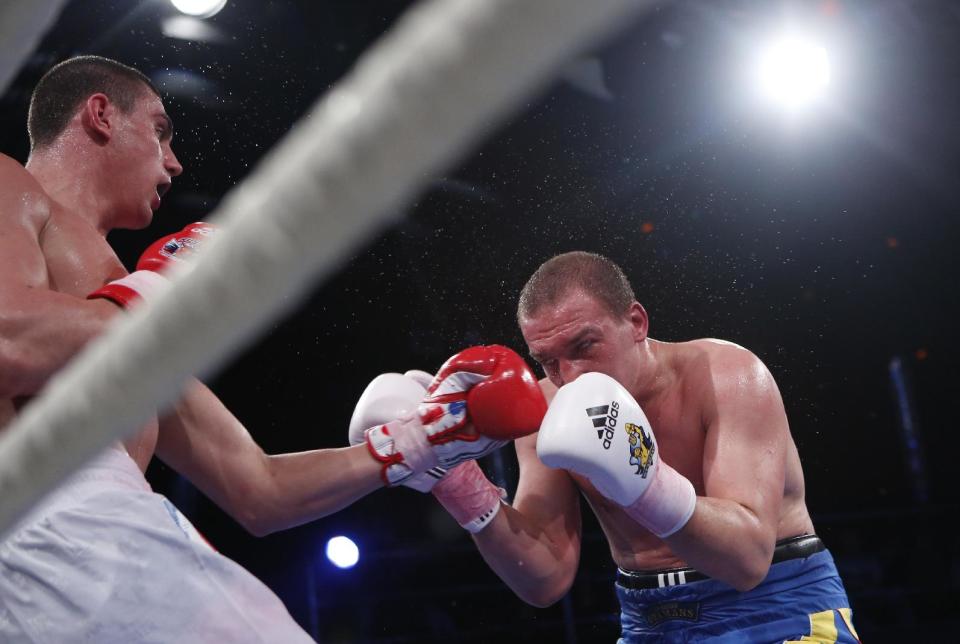 Ukraine's Sergei Korneev, left, in action with Russia's Yevgeny Tischenko during their heavyweight 91-kg World Series of Boxing quarterfinal bout between Russian Boxing Team and Ukraine Otamans, in Moscow, Russia, Monday, March, 31, 2014. Second leg matches will take part in Donetsk, Ukraine, on April 4. (AP Photo/Denis Tyrin)