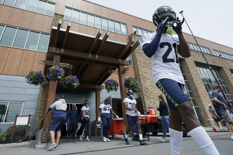 Seattle Seahawks cornerback Artie Burns, right, walks out of the Seahawks' headquarters building for NFL football practice on June 8, 2022, in Renton, Wash. (AP Photo/Ted S. Warren)