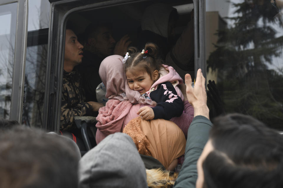 Migrants struggle to board a bus to go to the Greek border, in Istanbul, Friday, Feb. 28, 2020. NATO envoys were holding emergency talks Friday at the request of Turkey following the killing of 33 Turkish soldiers in northeast Syria, as scores of migrants gathered at Turkey's border with Greece seeking entry into Europe. (AP Photo/Omer Kuscu)