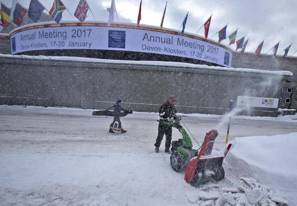 A municipality worker uses a snow blower to clear the area in front of the congress center where the annual meeting, World Economic Forum, will take place in Davos, Switzerland, Sunday Jan. 15, 2017. Business and world leaders are gathering for the annual meeting in Davos. (AP Photo/Michel Euler)