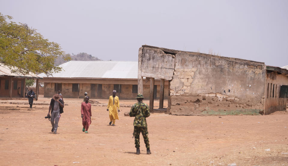 Shehu Lawal, right in yellow robe, whose 13-year-old son is among those abducted at the LEA Primary and Secondary School, walks back home after visiting the school in Kuriga, Kaduna, Nigeria, Saturday, March 9, 2024. The kidnapping on Thursday was only one of three mass kidnappings in northern Nigeria since late last week, a reminder of the security crisis that has plagued Africa's most populous country. No group claimed responsibility for any of the abductions but two different groups are blamed. (AP Photo/Sunday Alamba)