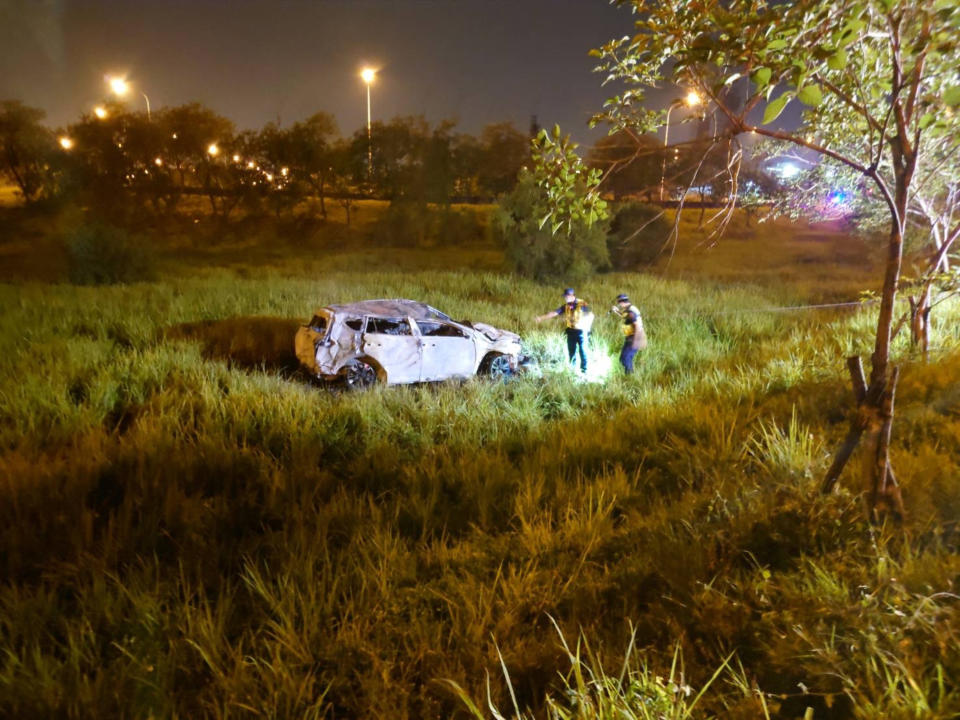 1輛自小客車30日凌晨疑衝破國道1號護欄，墜落邊坡起火，消防人員撲滅火勢後，在車內發現1具焦屍。（民眾提供）