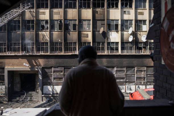 A man looks on at the burned apartment block in Johannesburg (AFP via Getty Images)