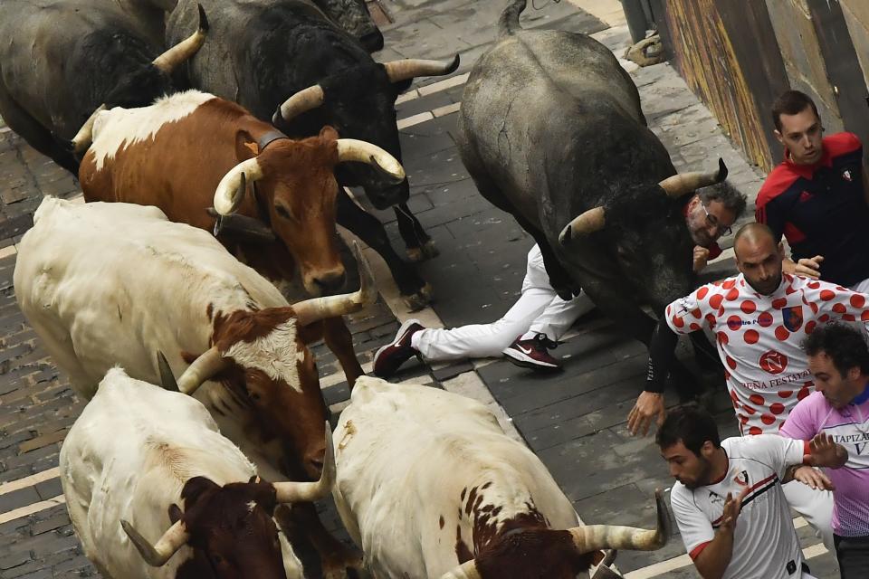 Revellers run next to fighting bulls during the running of the bulls at the San Fermin Festival, in Pamplona, northern Spain, July 9, 2019. (Photo: Alvaro Barrientos/AP)