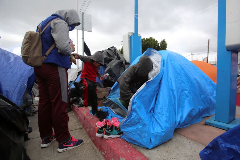 An asylum-seeking migrant talks to her children at an encampment of Mexican and Central American migrants, at El Chaparral crossing port with the U.S., in Tijuana