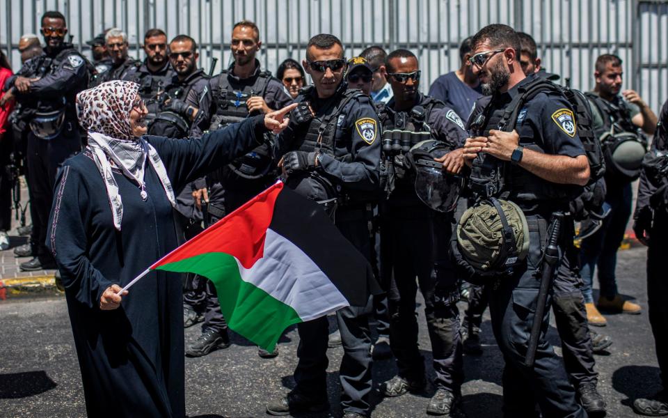 A Palestinian woman gestures at an Israeli policeman at a protest in East Jerusalem during the visit of US President Joe Biden - Avalon